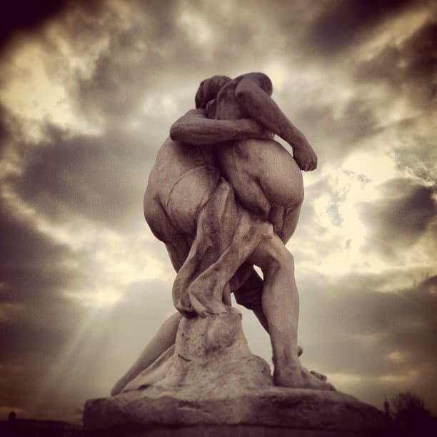 Statue of two mostly naked people facing away mooning us