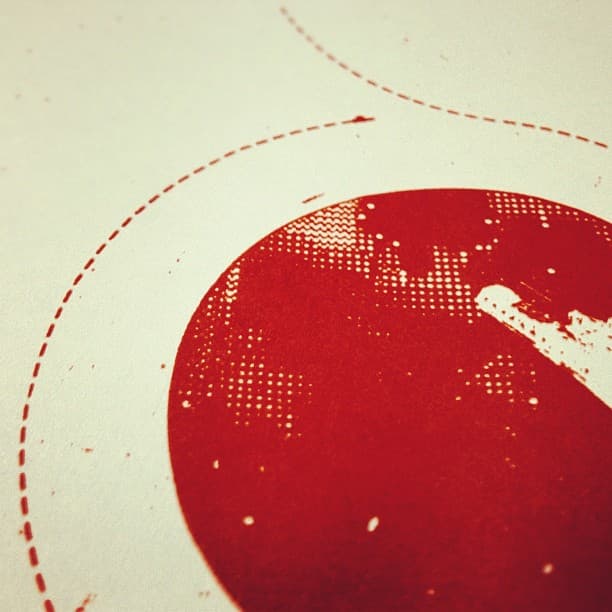 Closeup of a screen print depicting a spaceship orbiting a red planet